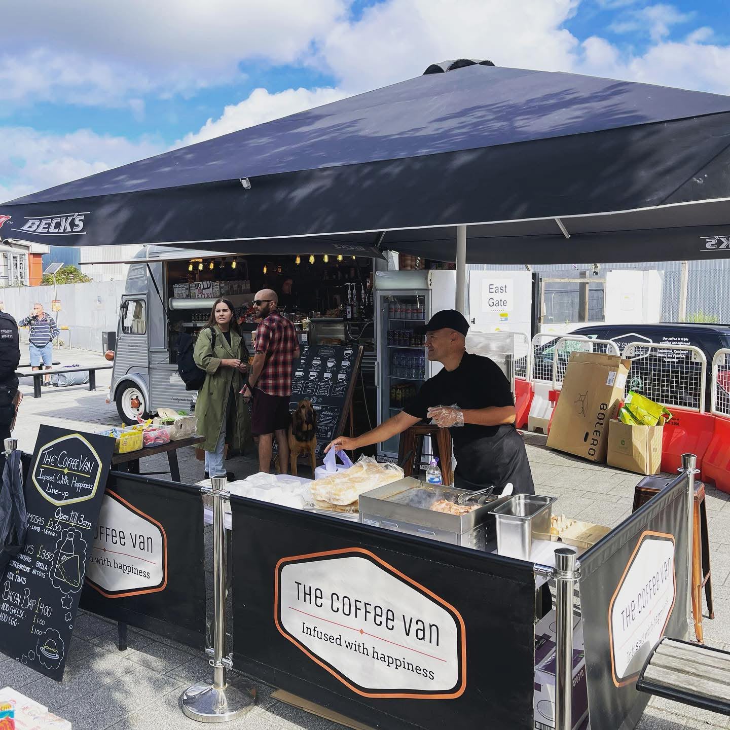 The Coffee Van team serving guests under a branded canopy