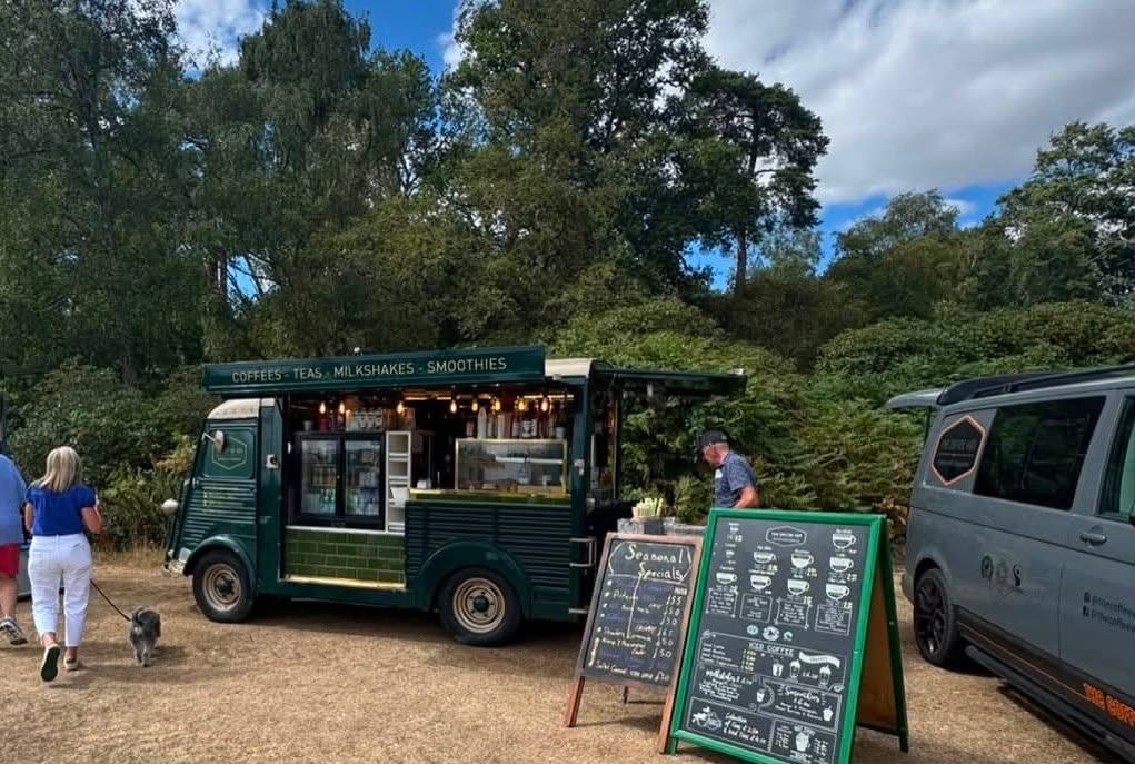 Green vintage coffee van serving at an outdoor countryside event