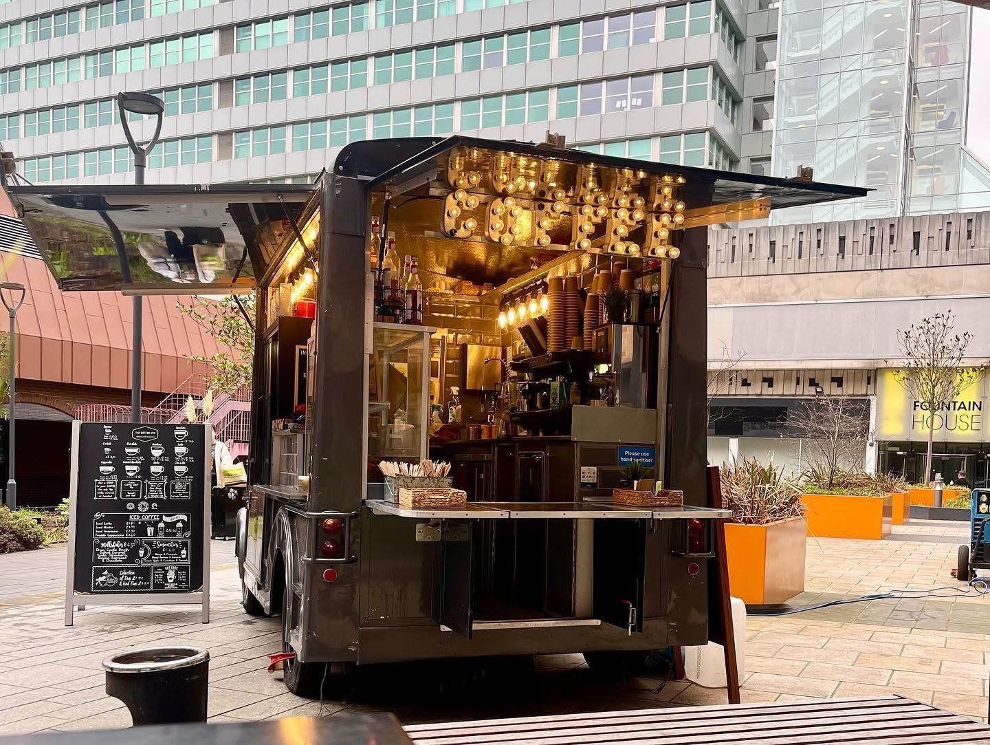 Black event coffee van at a corporate plaza